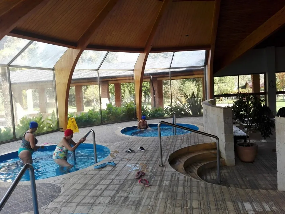 Piscinas termales interiores y arquitectura de madera en Termas de Catillo